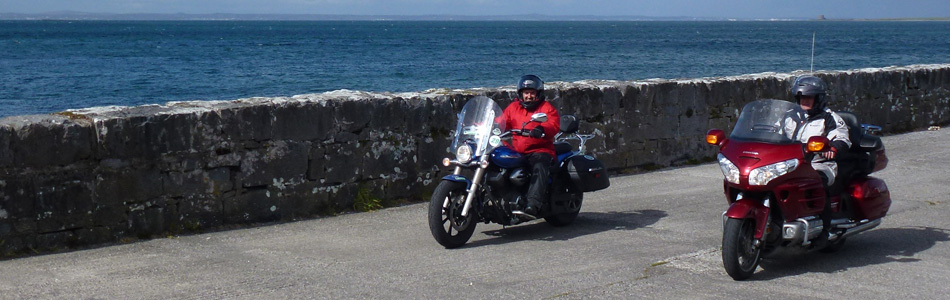 Deux motos customs, une Yamaha et un Honda, roulent en bord de mer en Irlande lors d'un road trip