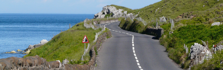 Petite route irlandaise au dessus de la mer, idéale pour un road trip à moto