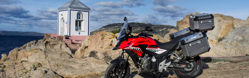 Lors d'un voyage en Sardaigne, une moto près d'un oratoire en bord de mer