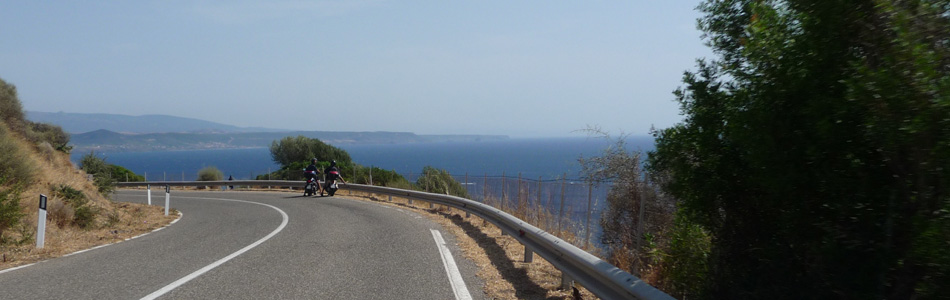 Deux motos arrêtés pour admirer la vue sur la mer durant un voyage en Sardaigne