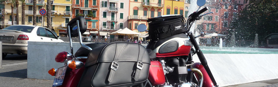 Vacances à moto en Toscane, une Triumph devant une fontaine et des bâtiments colorés